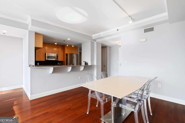 dining room featuring ornamental molding and dark wood-type flooring