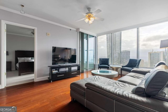 living room featuring hardwood / wood-style floors, ceiling fan, crown molding, and a wealth of natural light