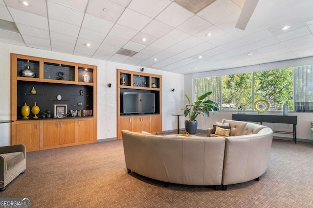 carpeted living room with a paneled ceiling