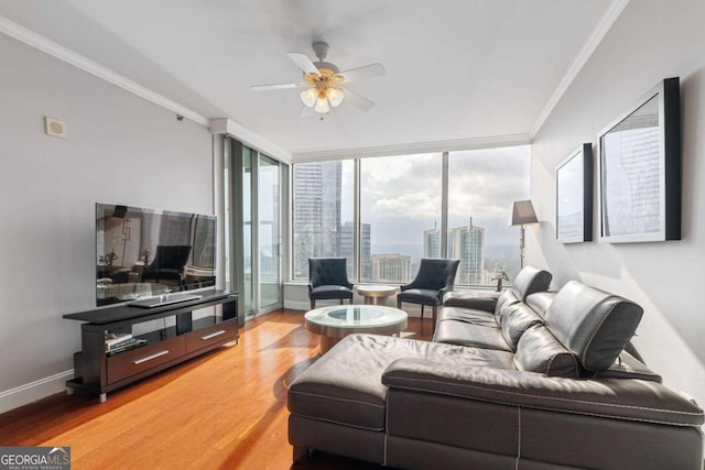 living room featuring a wall of windows, ceiling fan, hardwood / wood-style floors, and ornamental molding