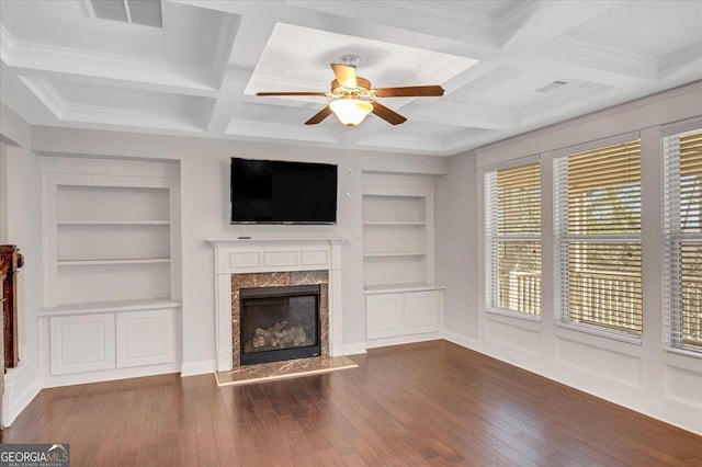 unfurnished living room featuring dark hardwood / wood-style floors, coffered ceiling, a fireplace, built in shelves, and beamed ceiling