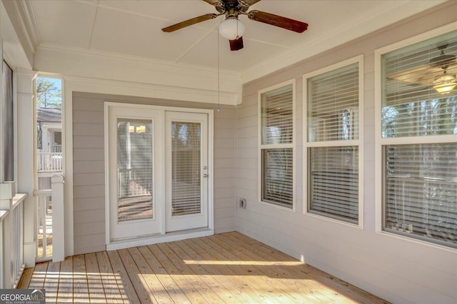 unfurnished sunroom with ceiling fan