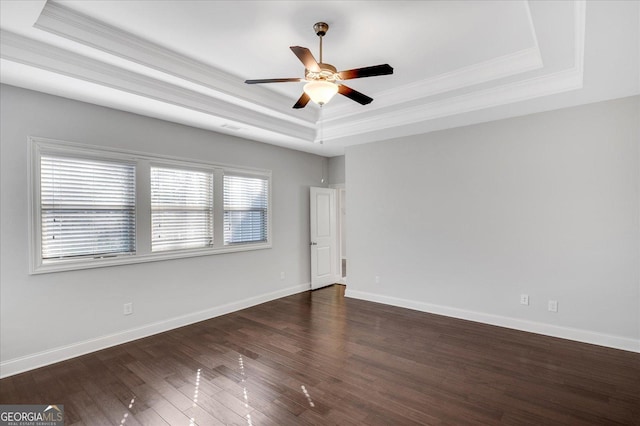 spare room with ceiling fan, ornamental molding, dark hardwood / wood-style floors, and a raised ceiling