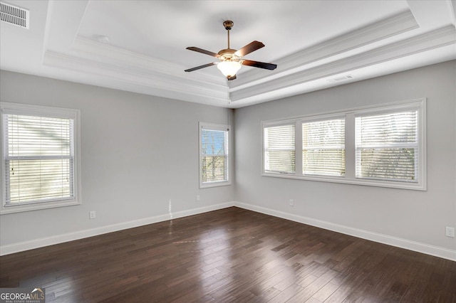 unfurnished room featuring ornamental molding, a tray ceiling, and dark hardwood / wood-style flooring