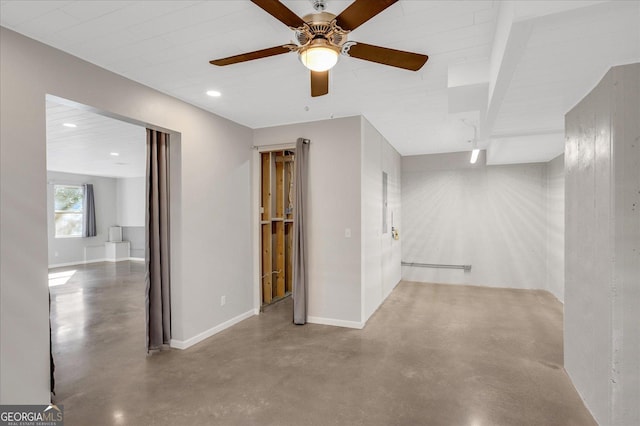 empty room with ceiling fan and concrete flooring