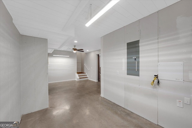 hallway with concrete flooring and electric panel