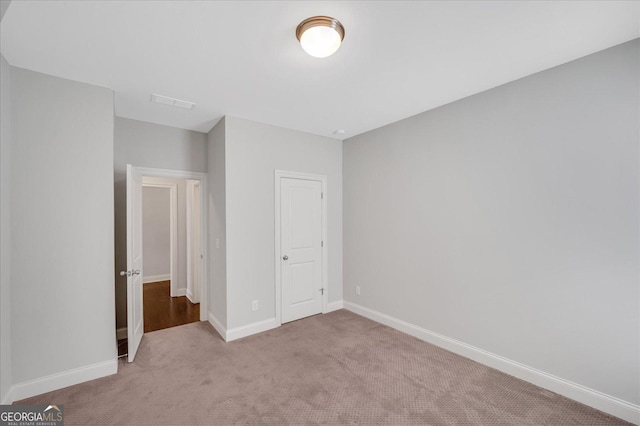 unfurnished bedroom featuring a closet and light carpet