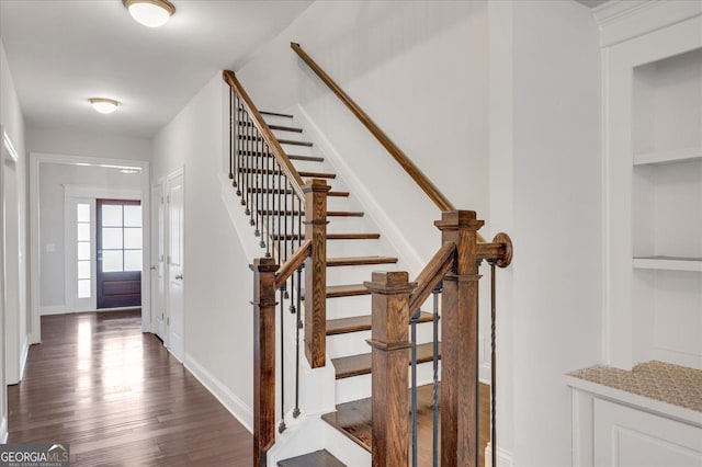 stairs with hardwood / wood-style floors and built in features