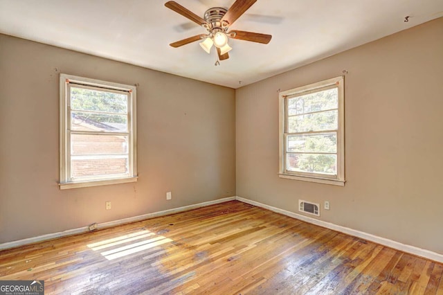 unfurnished room with light hardwood / wood-style flooring, ceiling fan, and a healthy amount of sunlight