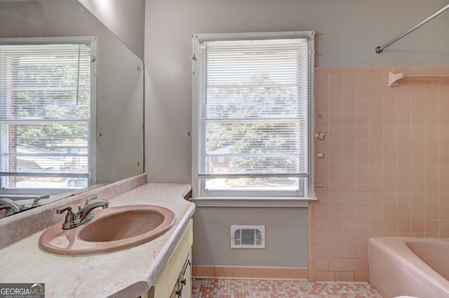 bathroom with tile patterned floors, a wealth of natural light, vanity, and bathing tub / shower combination