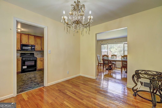 dining area with a chandelier and light hardwood / wood-style flooring