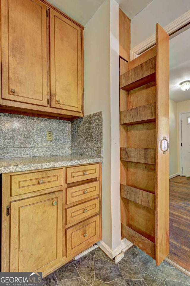 kitchen with dark hardwood / wood-style floors and backsplash