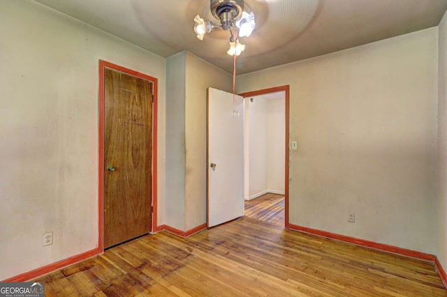 unfurnished bedroom featuring ceiling fan, a closet, and light hardwood / wood-style flooring