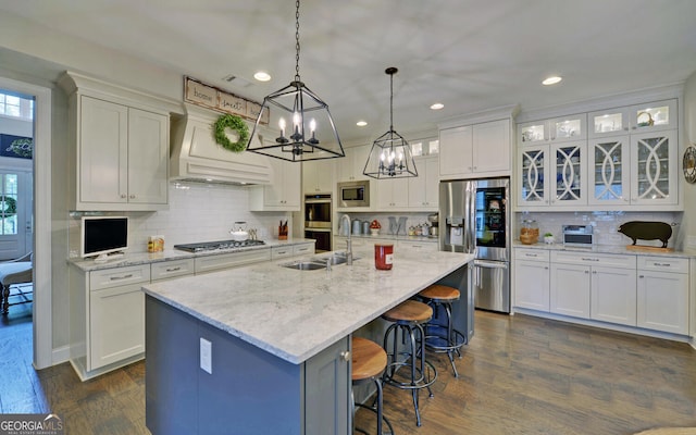 kitchen featuring white cabinetry, a center island with sink, and stainless steel appliances