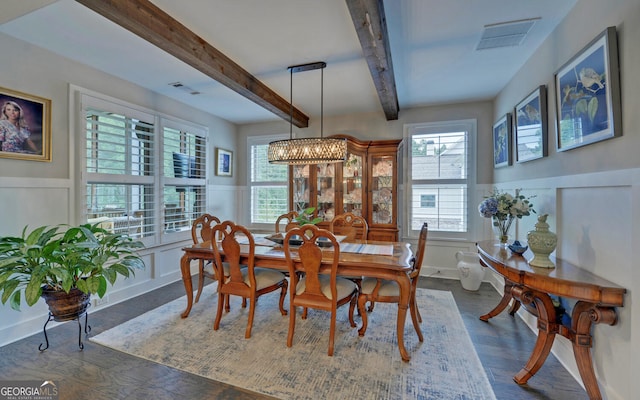 dining space with beam ceiling, dark hardwood / wood-style floors, and a notable chandelier