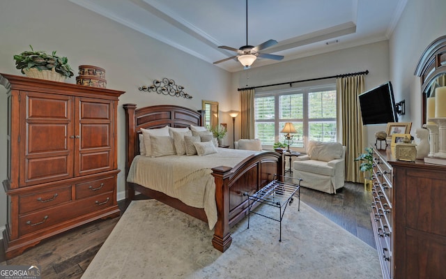 bedroom featuring a raised ceiling, ceiling fan, dark hardwood / wood-style flooring, and ornamental molding