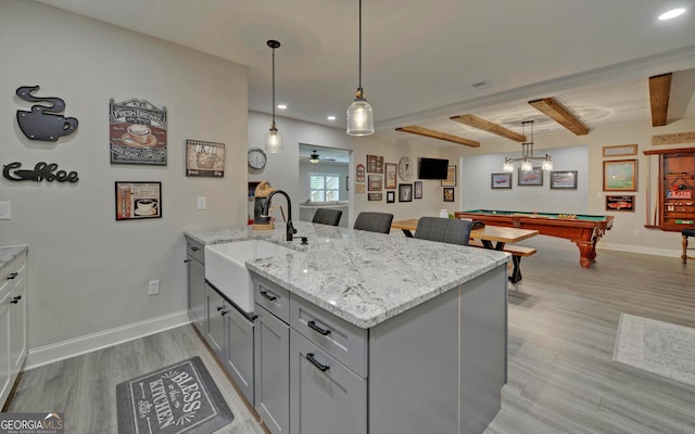 kitchen with ceiling fan, hanging light fixtures, beamed ceiling, billiards, and light hardwood / wood-style floors