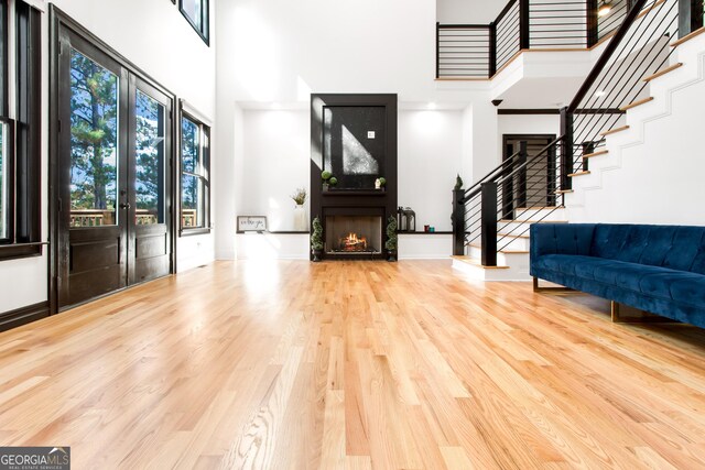 entrance foyer featuring a high ceiling, a large fireplace, and hardwood / wood-style floors