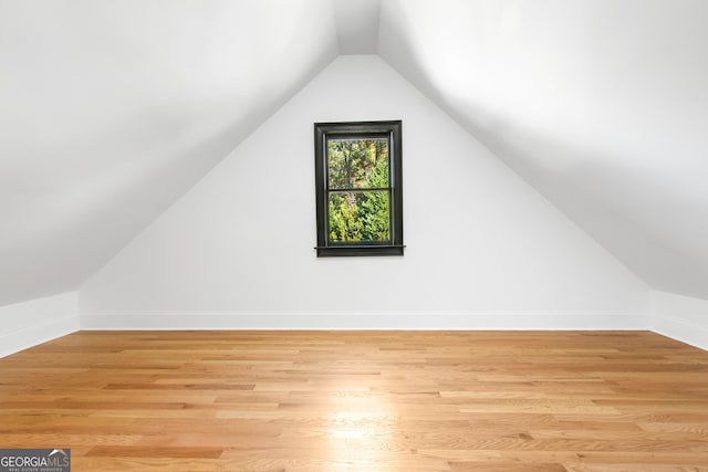 bonus room with light hardwood / wood-style flooring and lofted ceiling