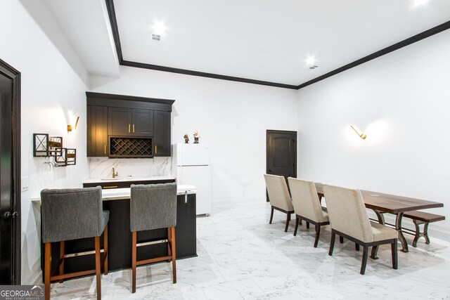 dining room with bar area and crown molding