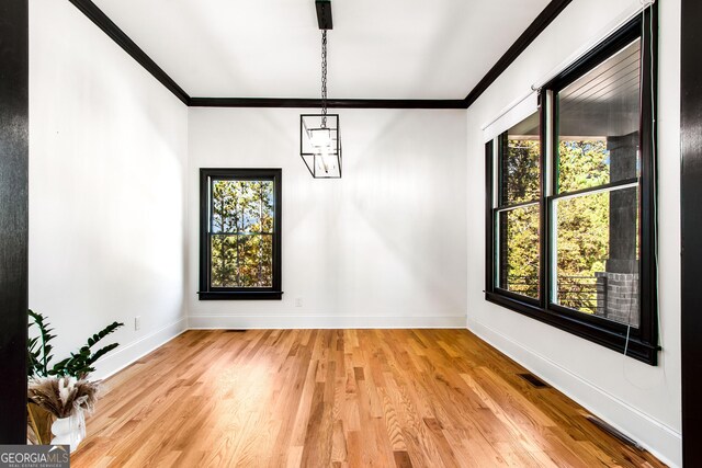 spare room with light hardwood / wood-style floors and crown molding