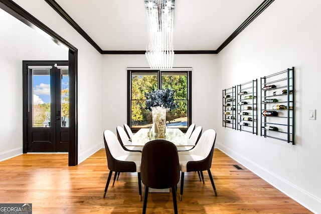 dining room featuring hardwood / wood-style flooring, a notable chandelier, and crown molding