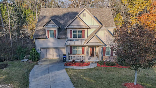 view of front of property featuring a front yard, a porch, and a garage