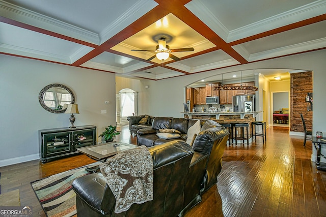 living room with dark wood-type flooring, crown molding, and coffered ceiling