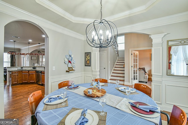 dining space featuring a wealth of natural light, hardwood / wood-style floors, crown molding, and an inviting chandelier