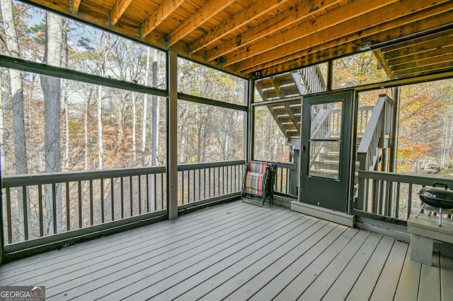 unfurnished sunroom featuring beam ceiling and wood ceiling