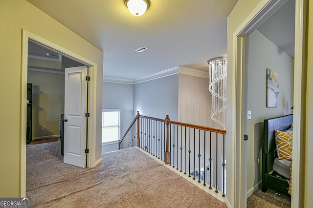 hall with crown molding, carpet floors, and a chandelier