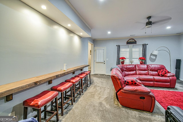 living room with carpet, ceiling fan, ornamental molding, and bar