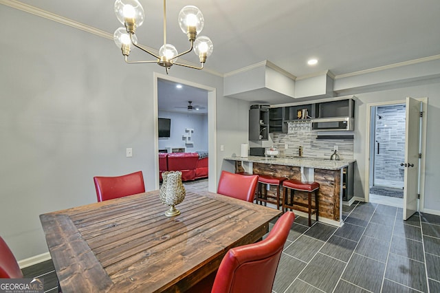 dining space featuring ceiling fan with notable chandelier and ornamental molding