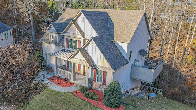 view of front of property with covered porch, a balcony, and a front lawn