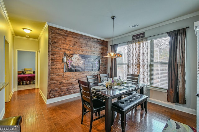 dining space with hardwood / wood-style floors, a healthy amount of sunlight, and ornamental molding