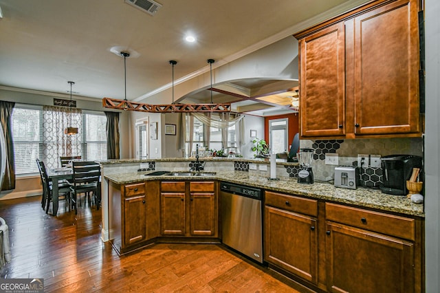 kitchen with dishwasher, dark hardwood / wood-style flooring, kitchen peninsula, and hanging light fixtures