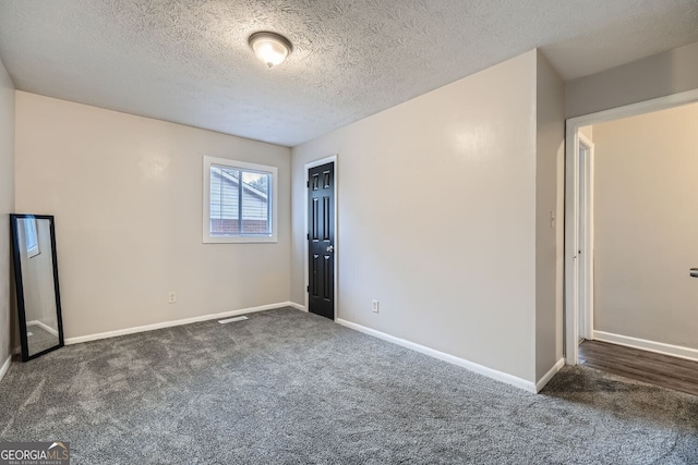 carpeted empty room with a textured ceiling