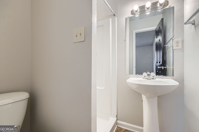 bathroom with sink, toilet, and a shower