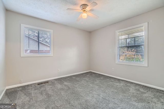 spare room with carpet flooring, ceiling fan, and a textured ceiling