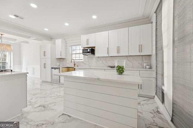 kitchen featuring white cabinets, a kitchen island, crown molding, and appliances with stainless steel finishes