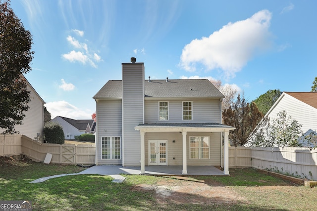 rear view of house featuring a lawn, a patio, and french doors