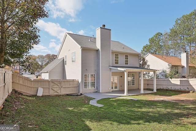 back of property with a lawn and a patio area