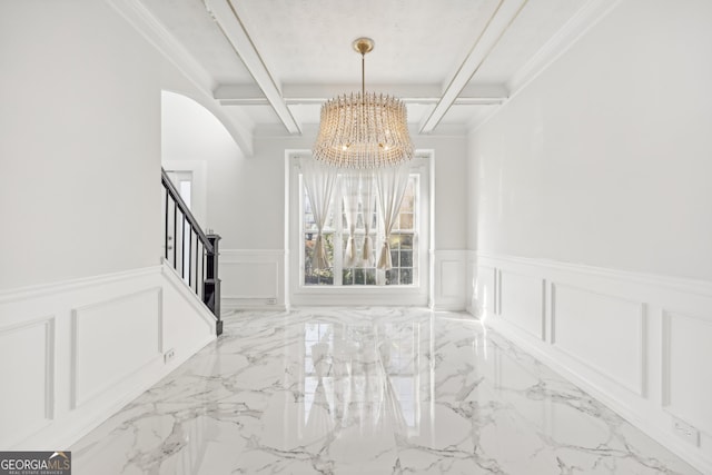 unfurnished dining area with beam ceiling, ornamental molding, and a chandelier