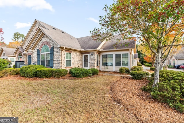 view of front property with central AC and a front yard