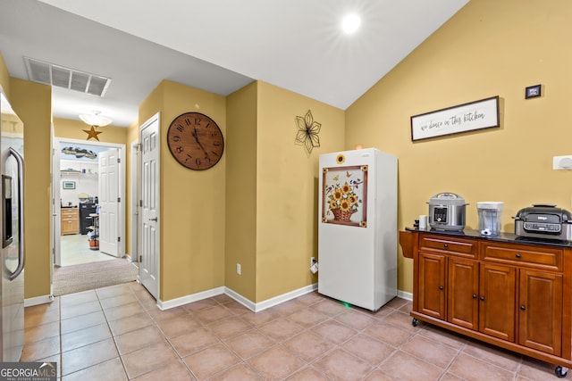 interior space featuring light tile patterned flooring and lofted ceiling