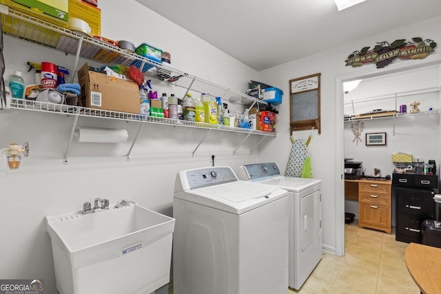 washroom with washing machine and clothes dryer, light tile patterned flooring, and sink