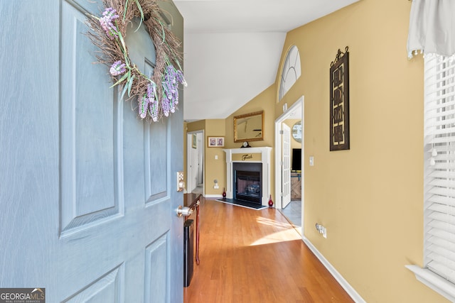 hall featuring vaulted ceiling and hardwood / wood-style flooring