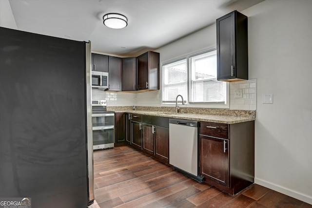 kitchen with backsplash, sink, dark hardwood / wood-style floors, and appliances with stainless steel finishes