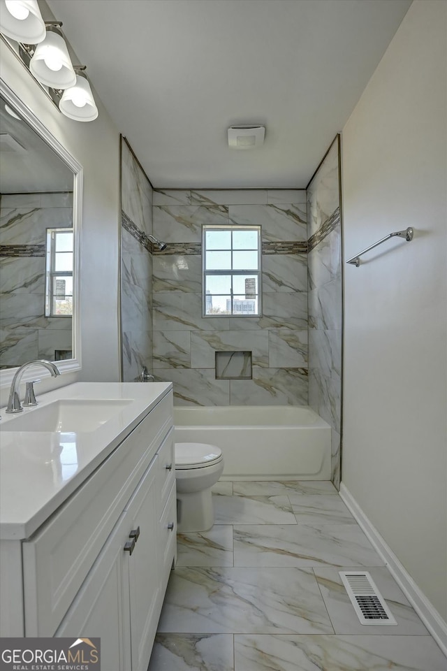 full bathroom with vanity, a healthy amount of sunlight, tiled shower / bath combo, and toilet