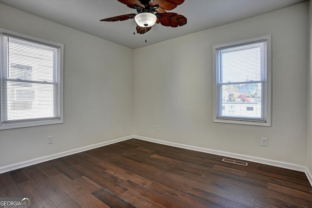 unfurnished room with a wealth of natural light, ceiling fan, and dark hardwood / wood-style floors